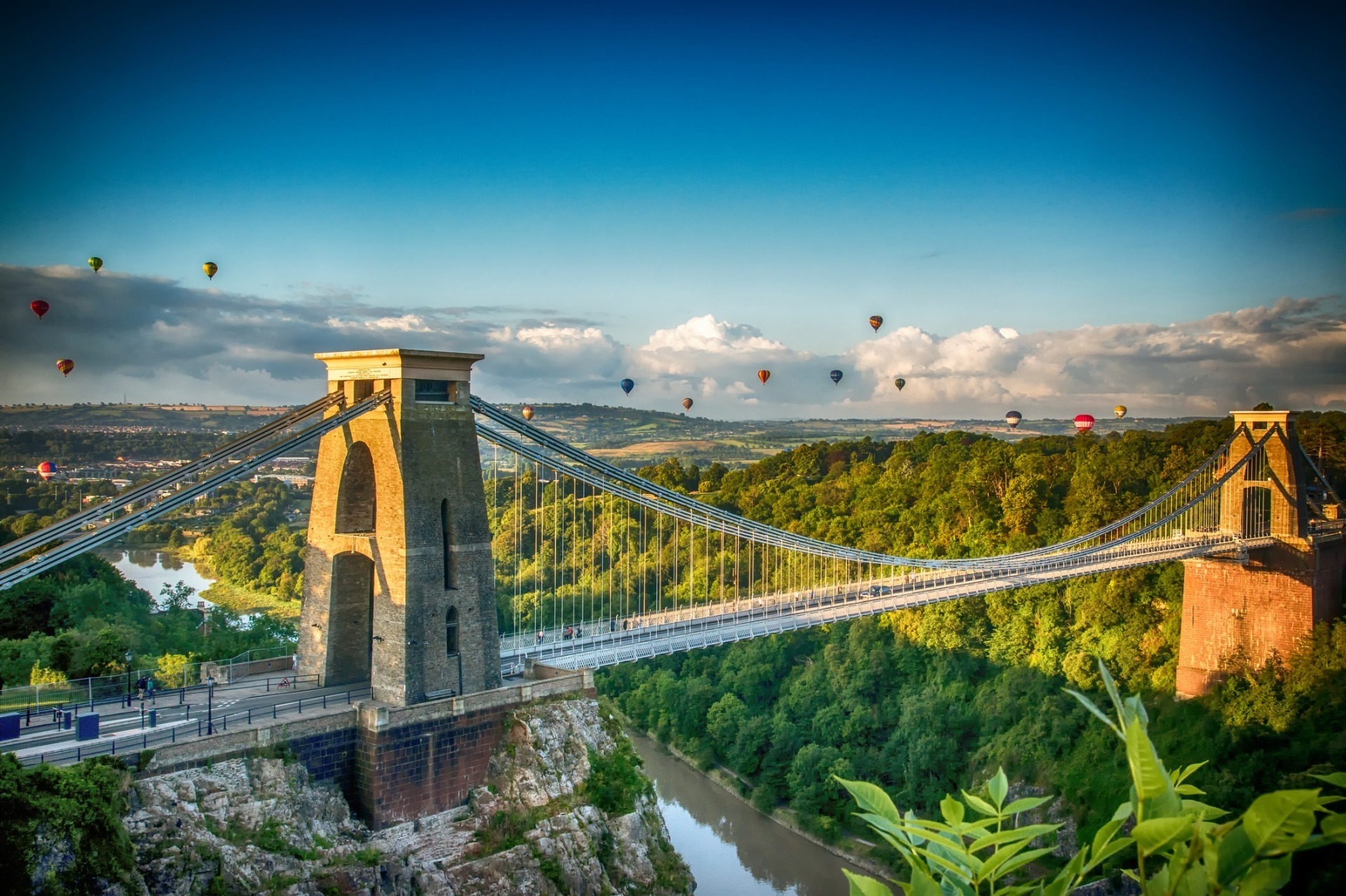 A sunny day showing Bristol's suspension bridge with hot air balloons in the sky